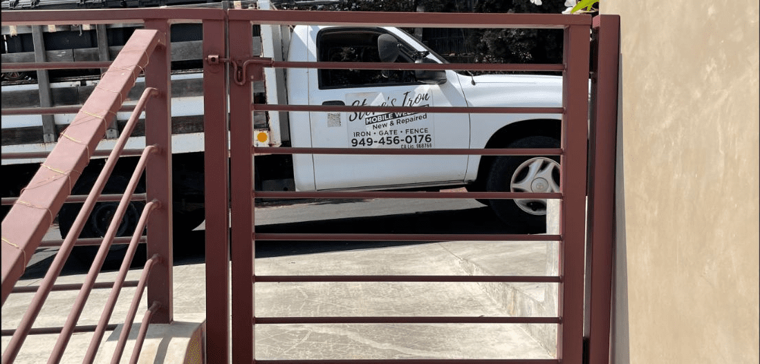 A white truck parked in front of a red fence.