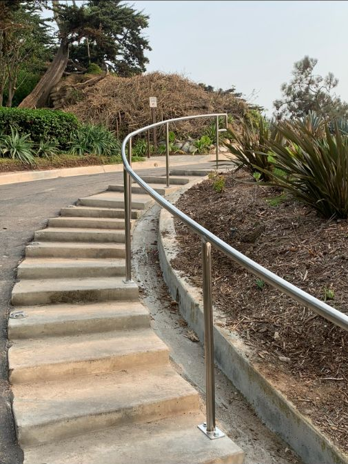 A concrete staircase with metal railing on the side.