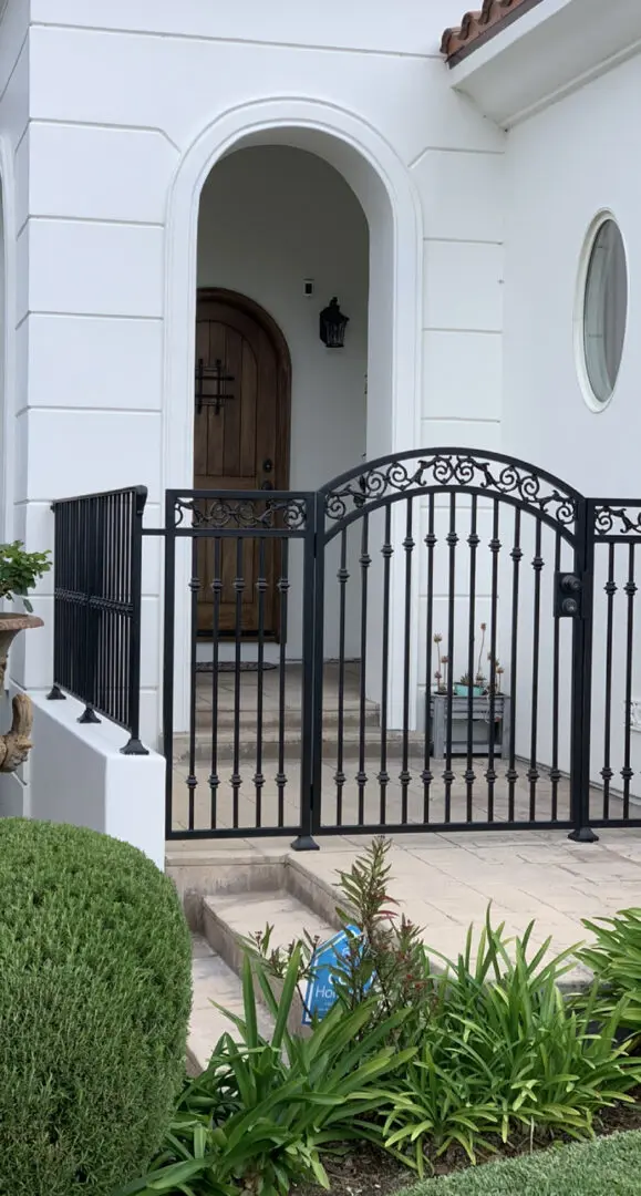 A gate that is open and has a flower pot on the side of it.