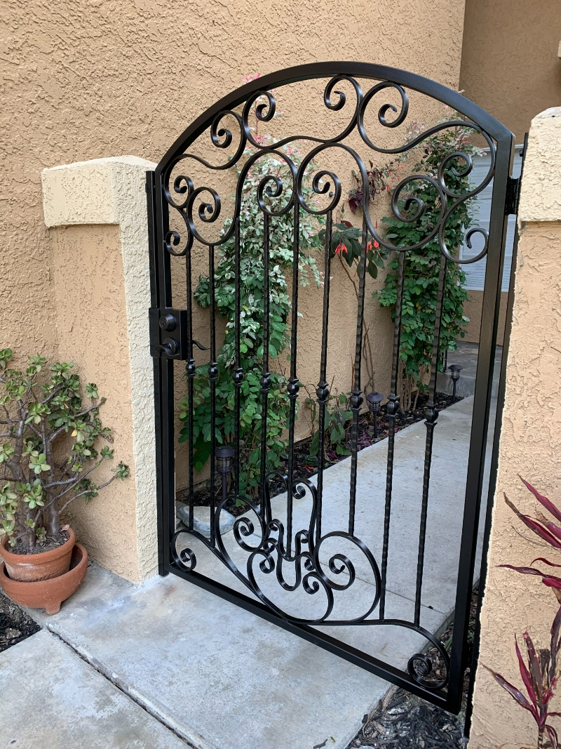 A gate that is open and has plants in it.