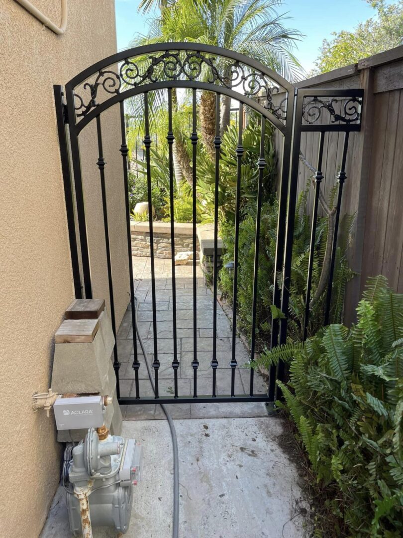 A gate that is open and has plants in it.