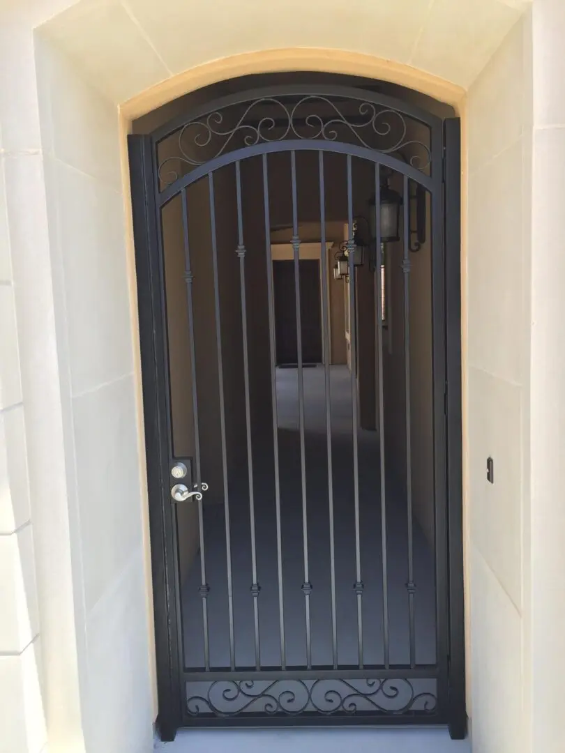 A door with a metal grill and a wrought iron design.