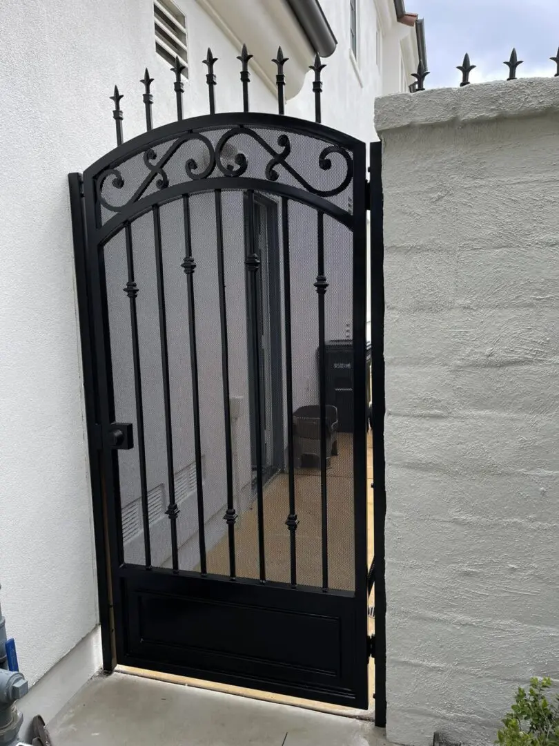 A black metal gate with a mirror on the side.