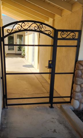 A metal gate with a wrought iron design.