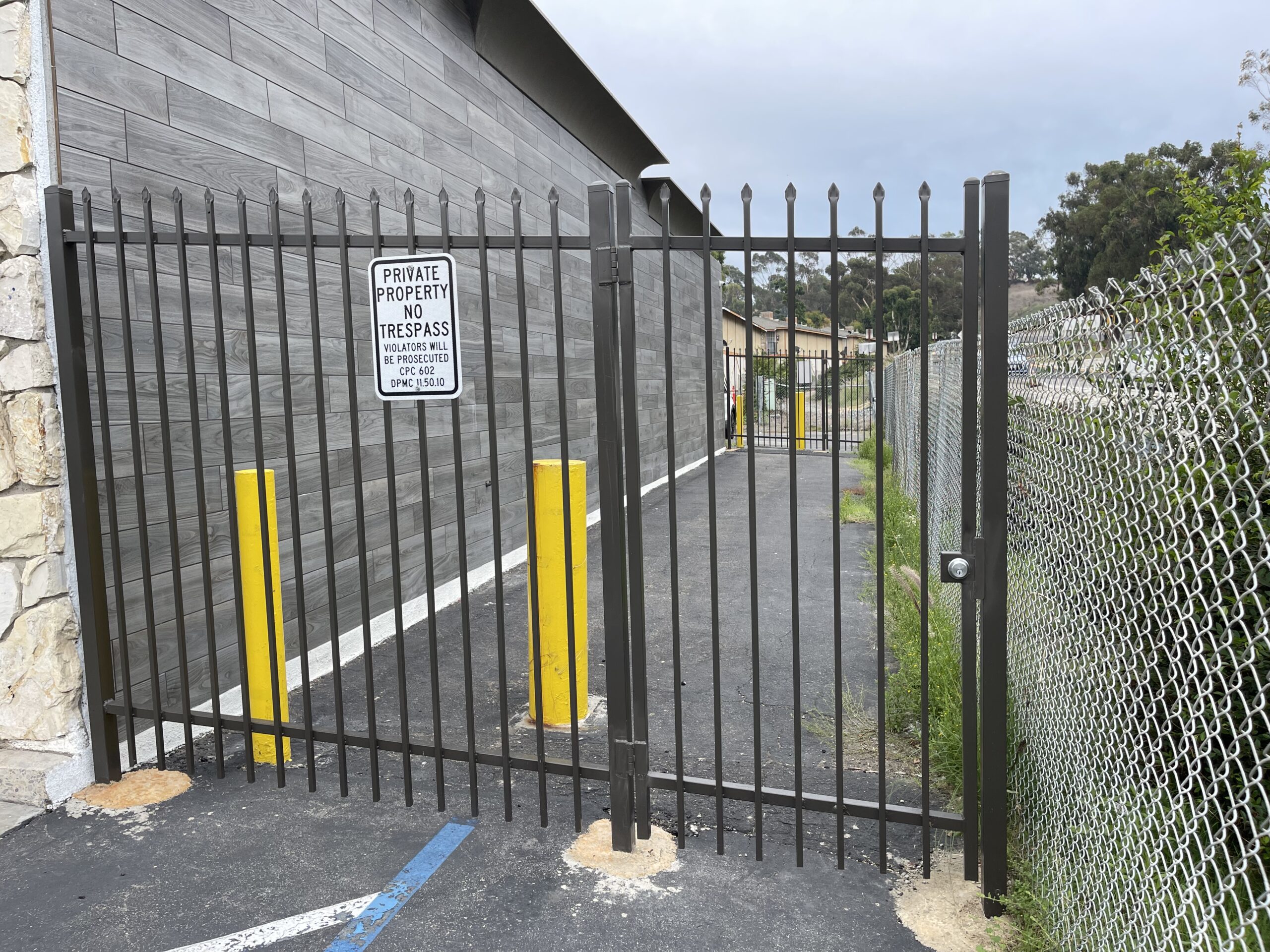A gated driveway with no parking signs on the side.