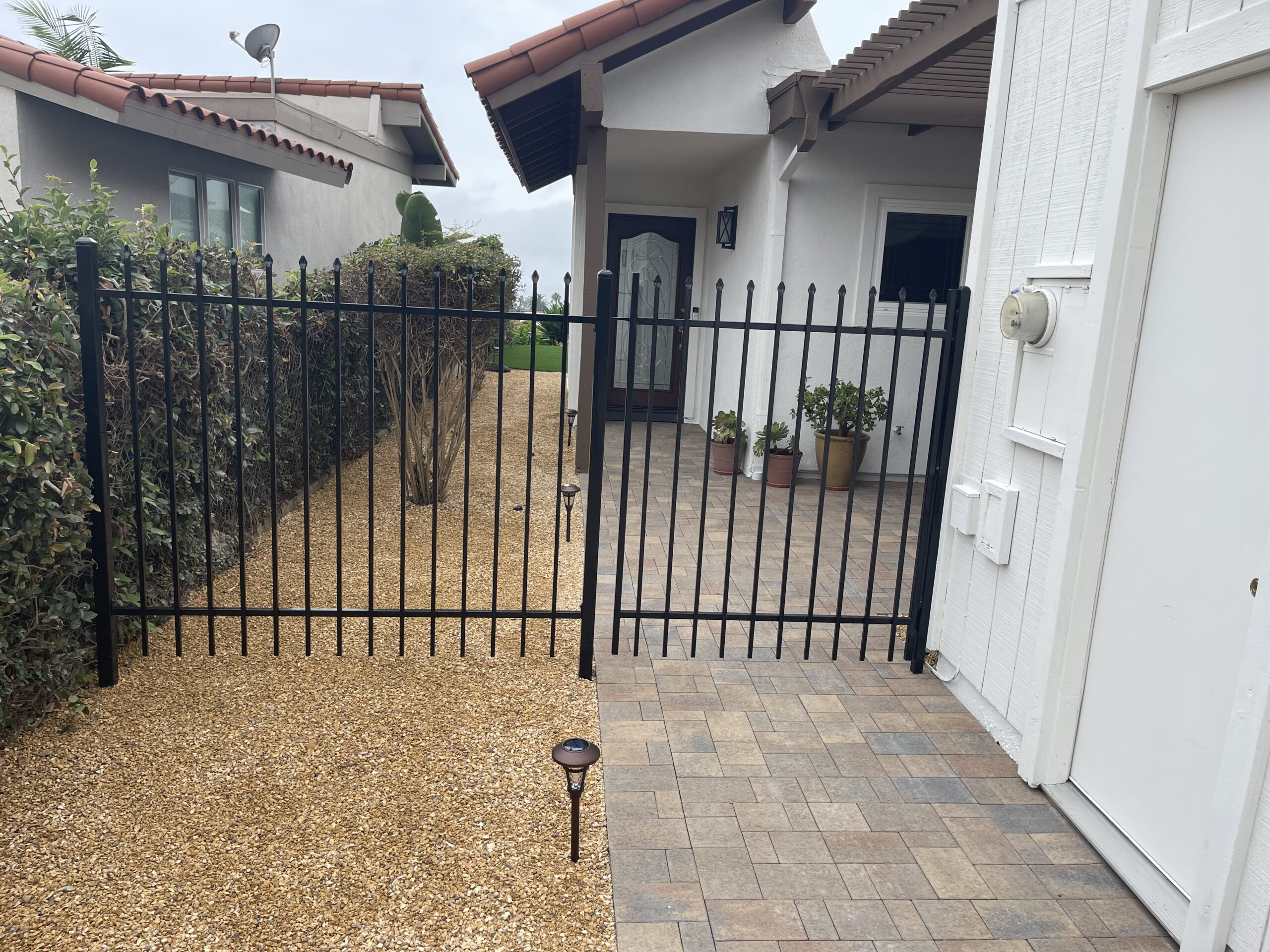 A gated driveway with a walkway and a gate.