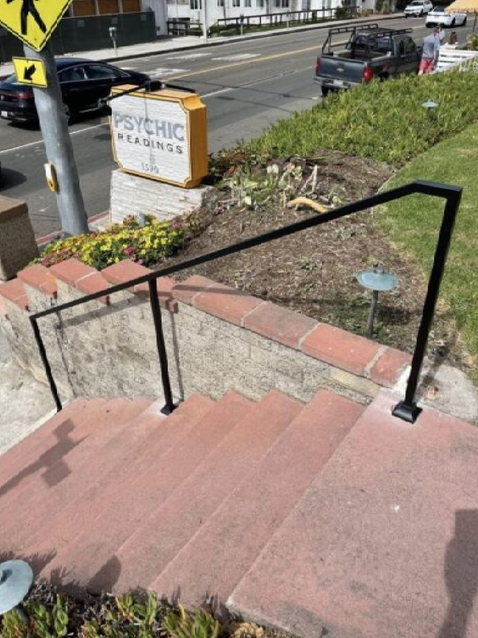 Staircase with black handrail and psychic sign.