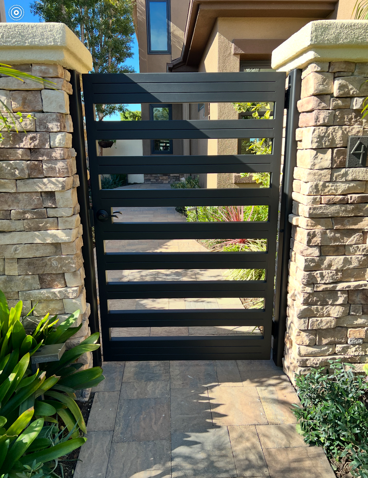 Modern metal gate with stone pillars.