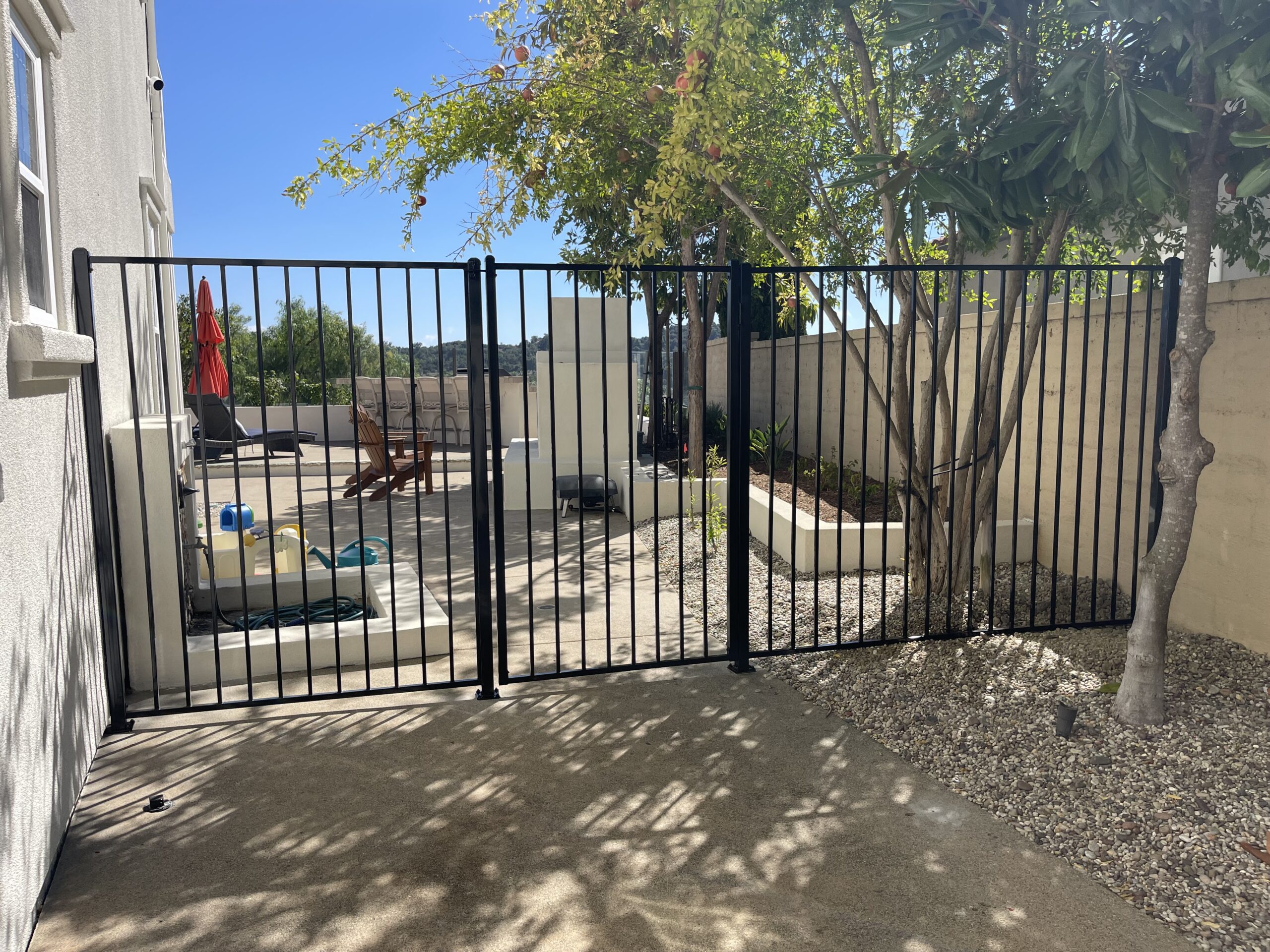Black metal gate with patio view.