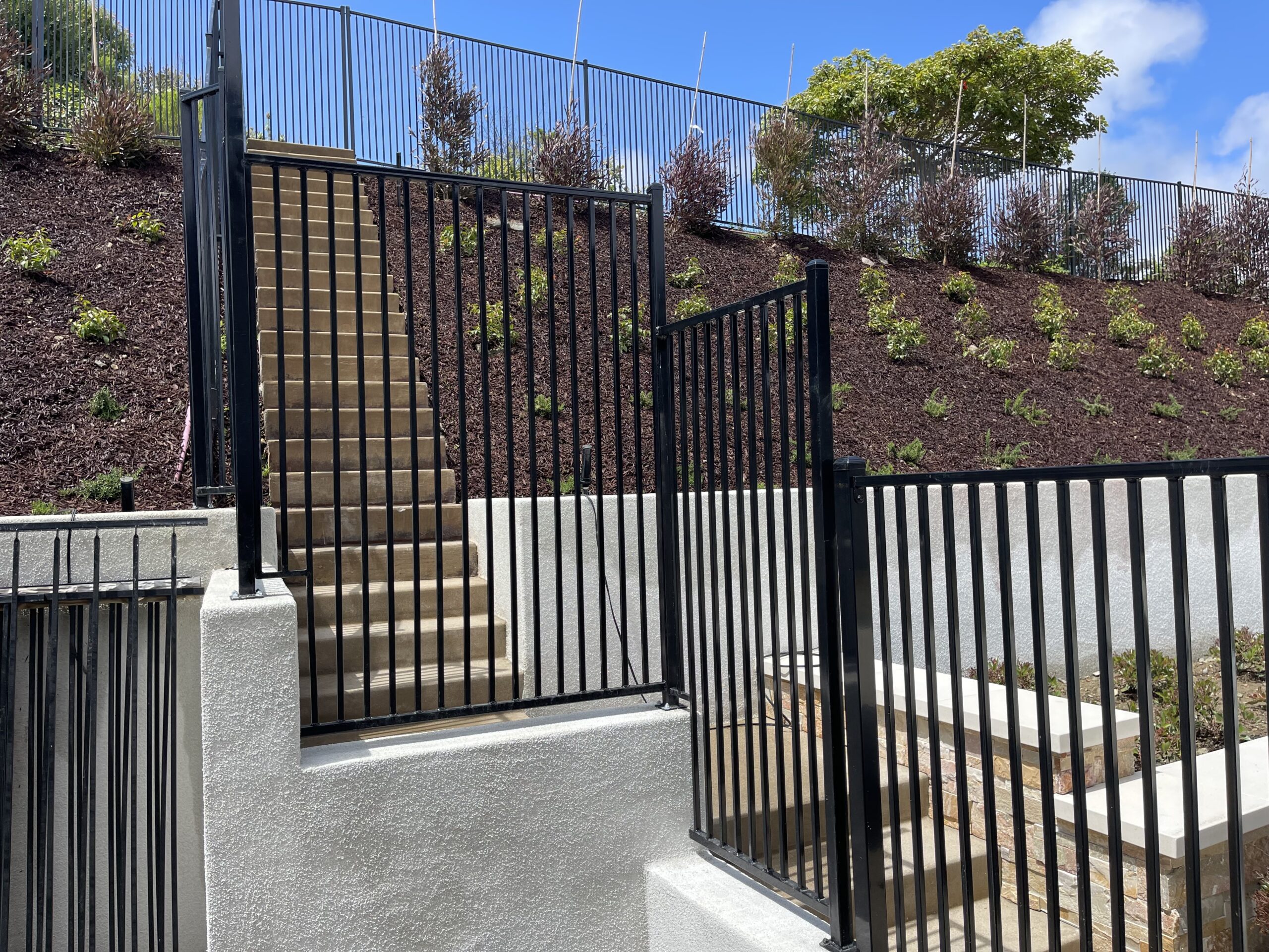 Staircase with black metal fence outdoors.