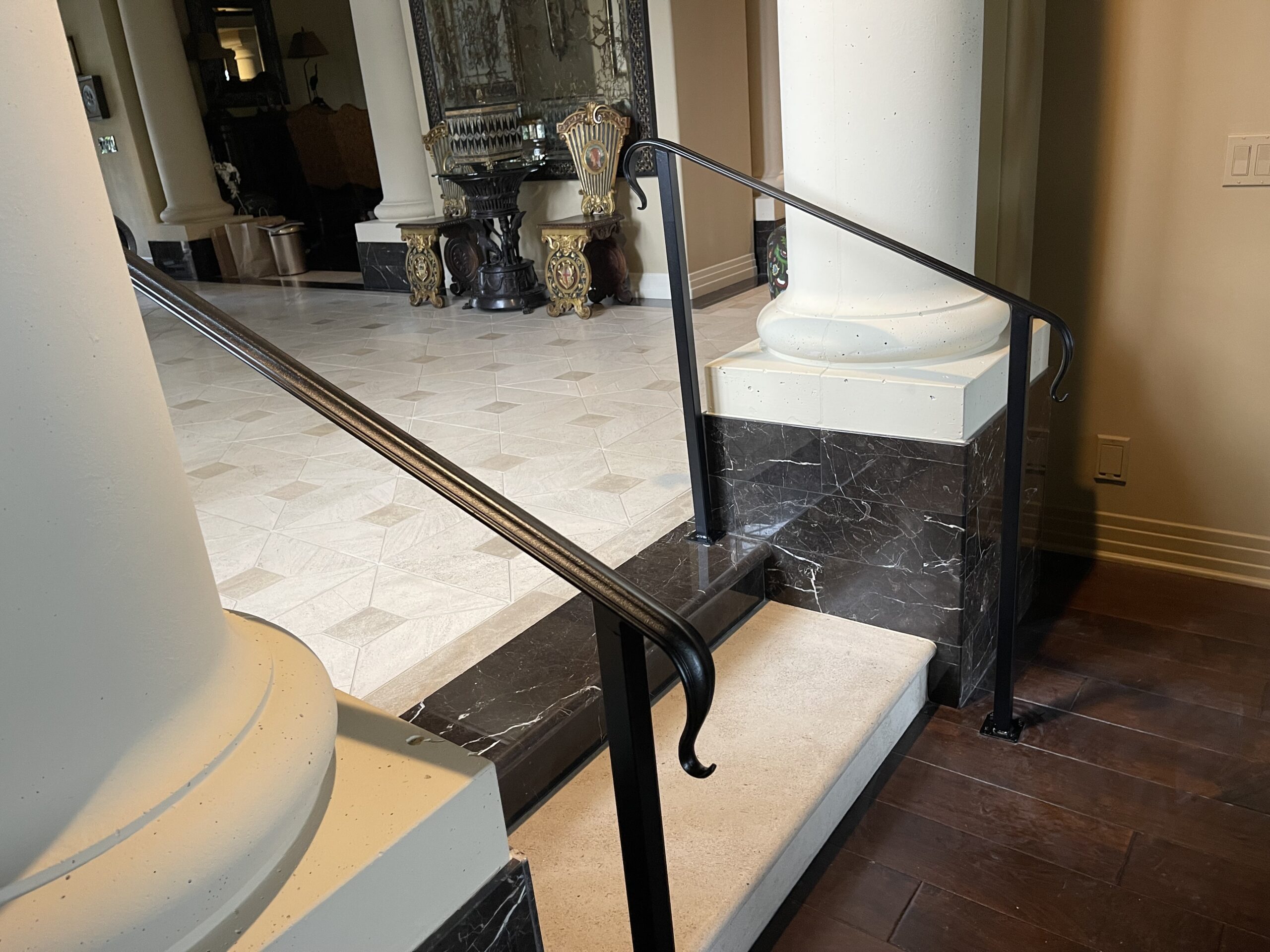 Marble steps with black iron handrails indoor.